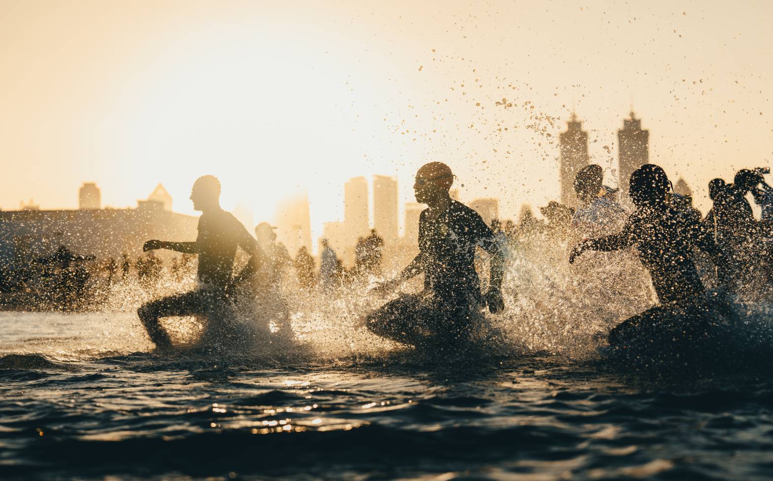 Age-group athletes run into the water for the start of the Dubai T100 Sprint Triathlon