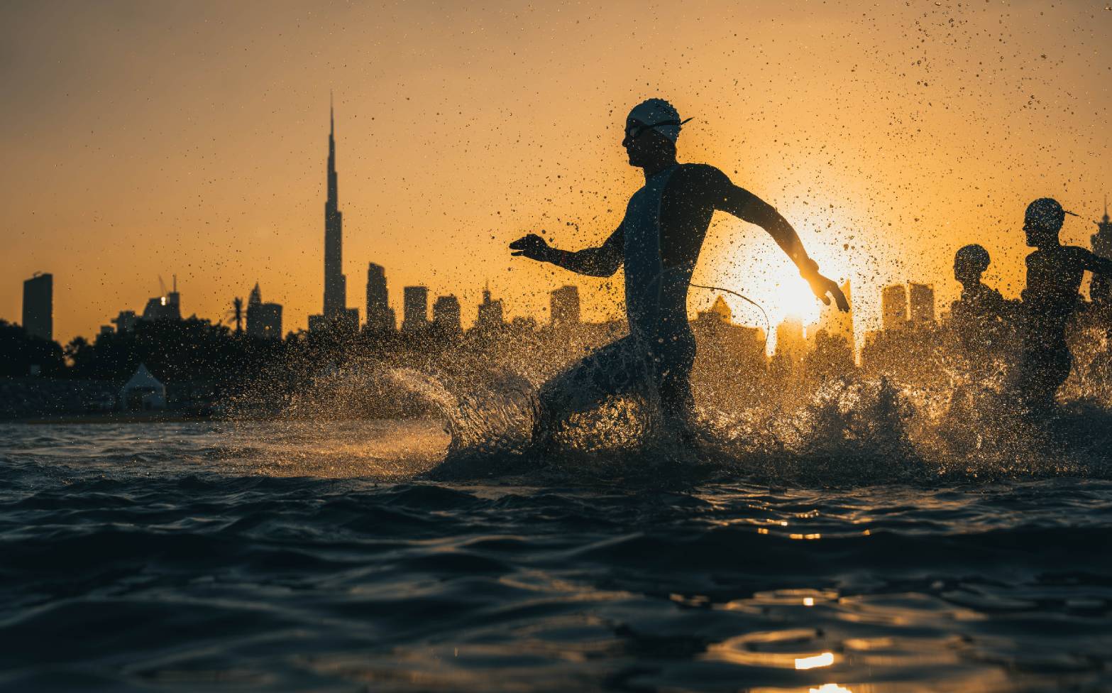 Swimmer running into the water for the start of the Dubai T100